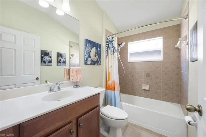 2nd Bathroom featuring vanity, shower / tub combo with curtain, and light tile floors