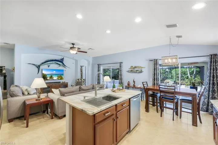Kitchen featuring granite counters, recessed lighting, walnut cabinetry, dining area and open floor plan