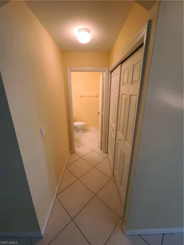 Hallway to downstairs half bath, with doors to laundry area on the right