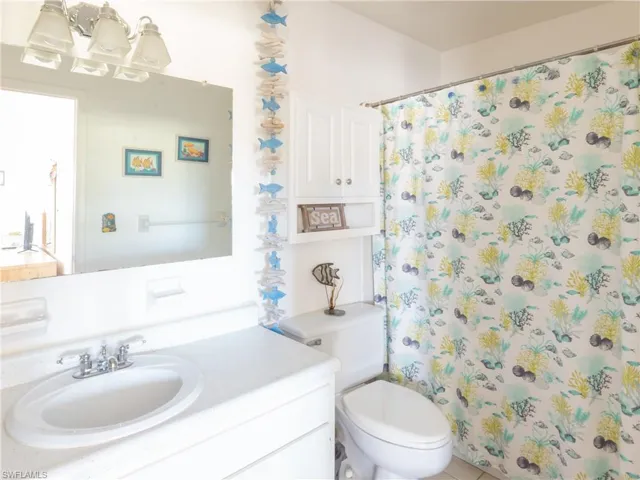 Full bath featuring vanity, curtained shower, and a chandelier