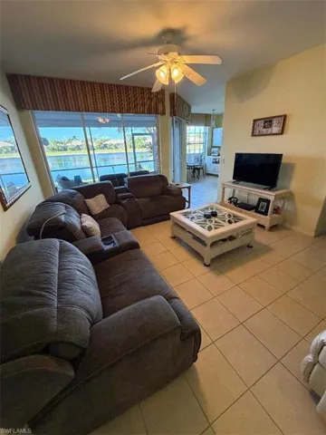 Living area featuring light tile patterned flooring and ceiling fan