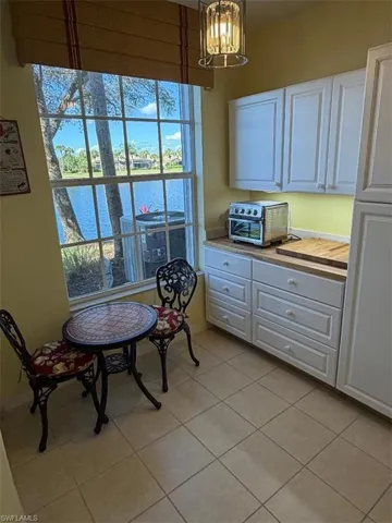 Dining space featuring a water view, a chandelier, and light tile patterned floors