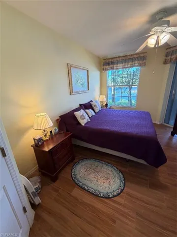Bedroom with ceiling fan and dark wood-style floors