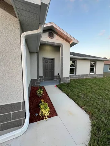 Entrance to property with a lawn