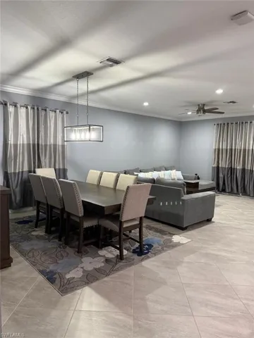 Dining space featuring crown molding, light tile patterned floors, recessed lighting, and a ceiling fan