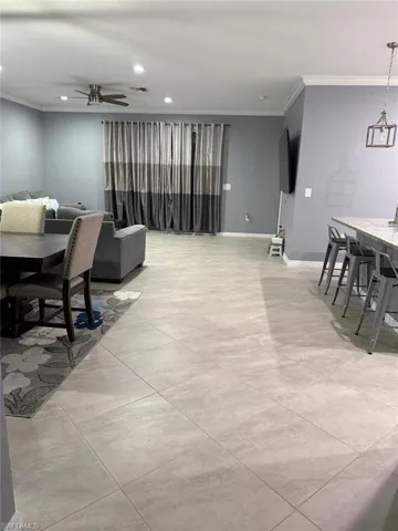 Dining room with crown molding, ceiling fan, and recessed lighting