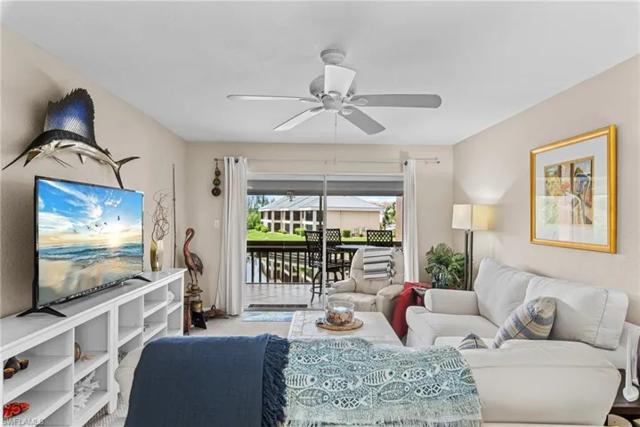 Carpeted living area featuring a ceiling fan