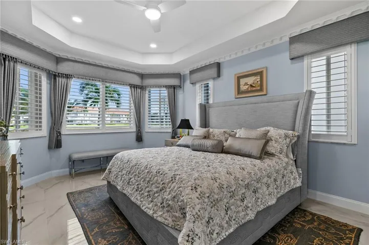 Bedroom featuring ceiling fan and a tray ceiling
