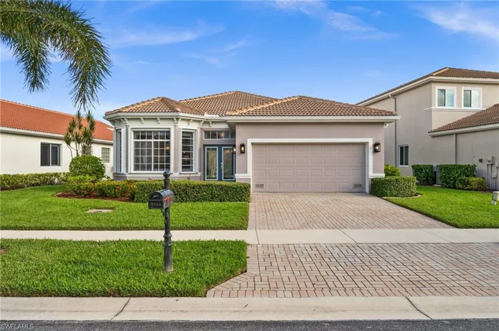 Mediterranean / spanish house with a garage and a front lawn