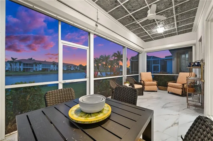 Sunroom / solarium featuring a water view and ceiling fan