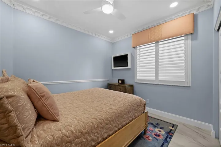 Bedroom with ceiling fan and crown molding