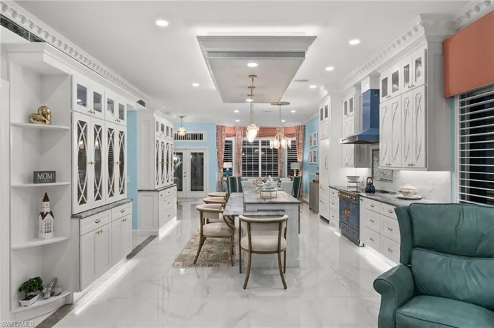 Kitchen featuring pendant lighting, white cabinets, and a center island