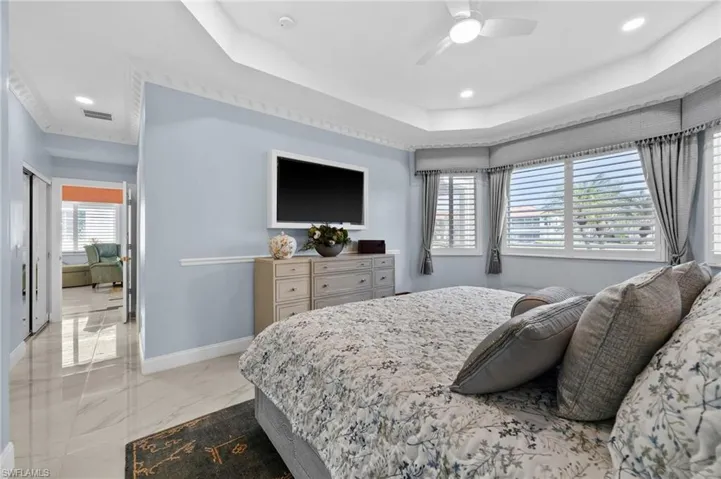 Bedroom with multiple windows and ceiling fan