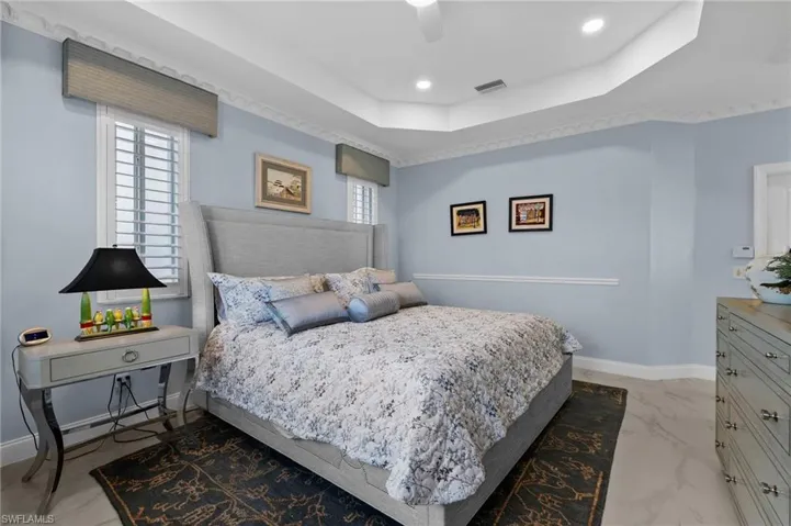 Bedroom with ceiling fan and a tray ceiling