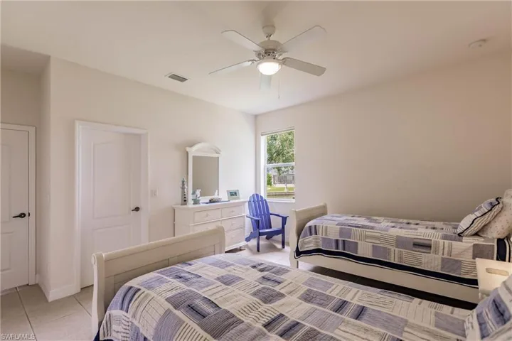 Tiled bedroom featuring ceiling fan