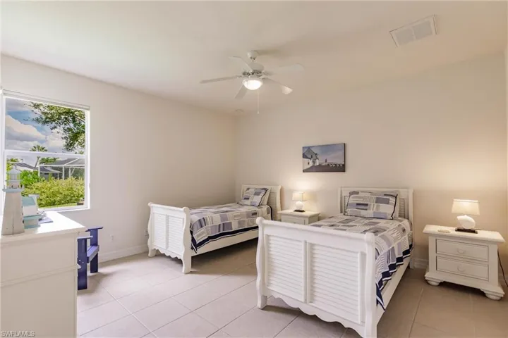 Bedroom with ceiling fan and light tile patterned floors