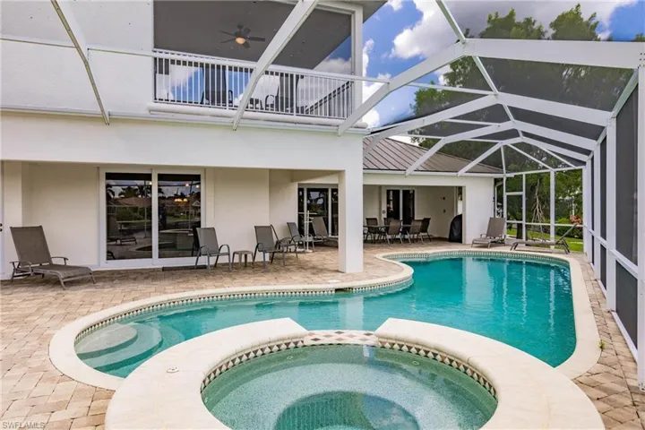 View of swimming pool with an in ground hot tub, a lanai, ceiling fan, and a patio