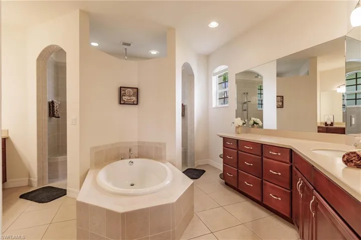 Bathroom with tile patterned floors, separate shower and tub, and vanity