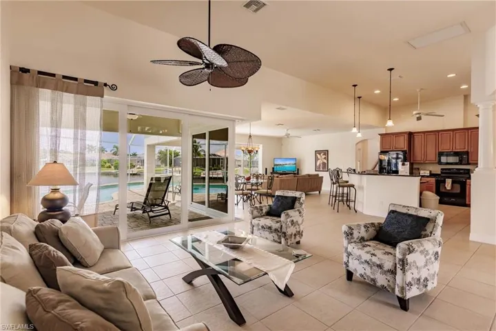 Tiled living room featuring ceiling fan and a towering ceiling