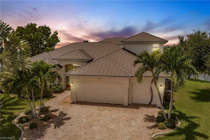 View of front of home with a garage and a yard