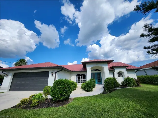 View of front of property featuring a garage and a front lawn