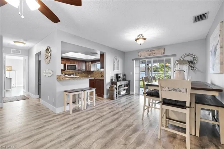 Dining room featuring a textured ceiling, ceiling fan, and light wood-type flooring