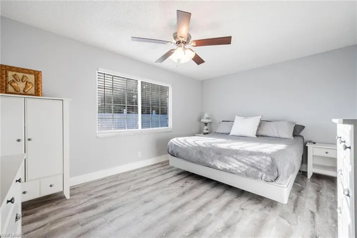 Bedroom featuring a textured ceiling, ceiling fan, and light wood-type flooring