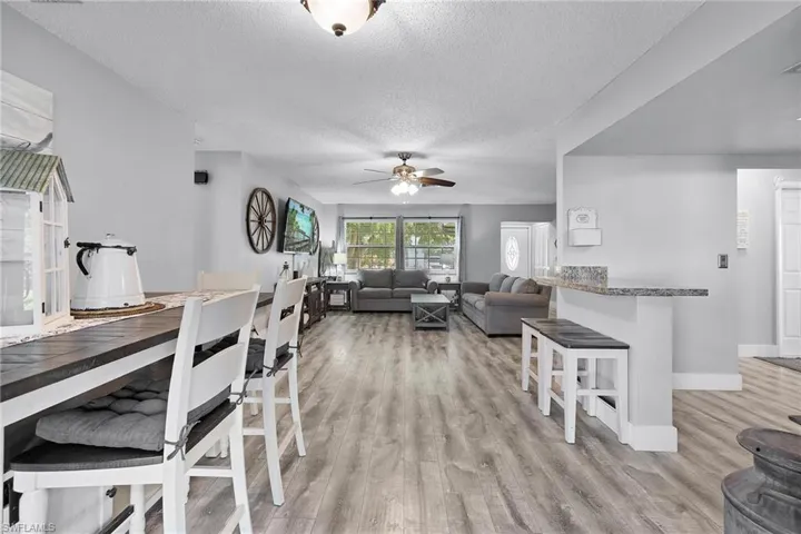 Dining room with ceiling fan, a textured ceiling, and light hardwood / wood-style flooring