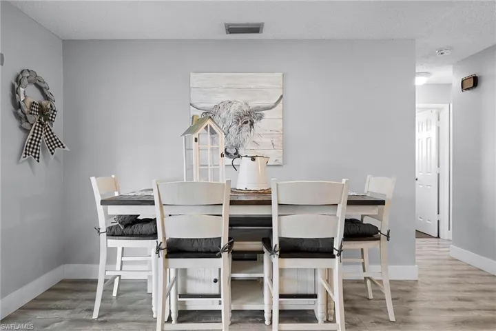 Dining room with light hardwood / wood-style floors and a textured ceiling