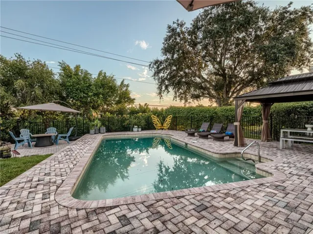 Encircling yard is a classic iron picket fence and mature hedges