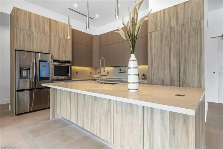 Highlighted by SOFT PASTEL TONES, CUSTOM CABINETRY with premium doors and drawers and a WALK-IN PANTRY