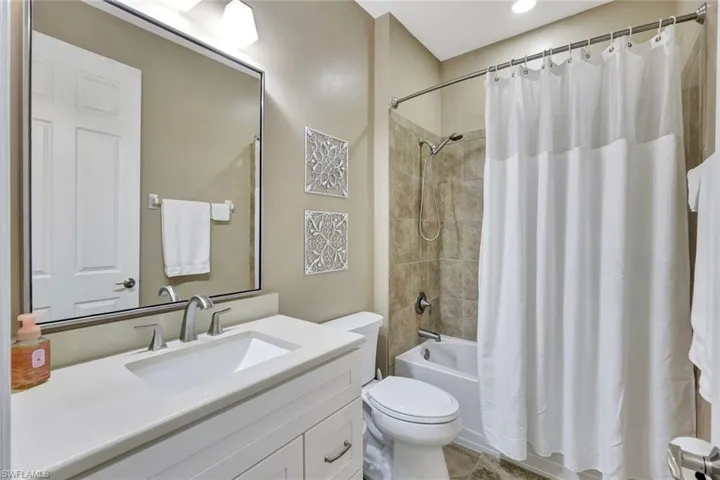 Full bathroom with toilet, vanity, and shower / bath combo