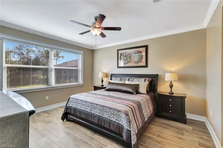 Bedroom with ceiling fan and crown molding