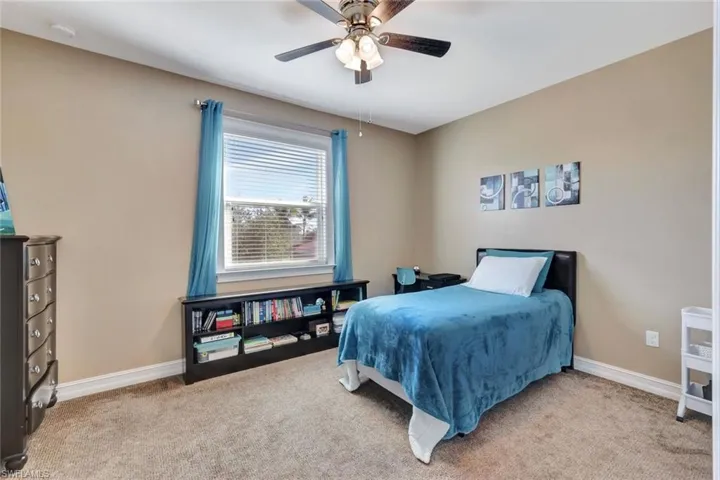 Carpeted bedroom with ceiling fan