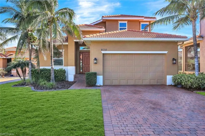 Mediterranean / spanish house with a garage and a front lawn