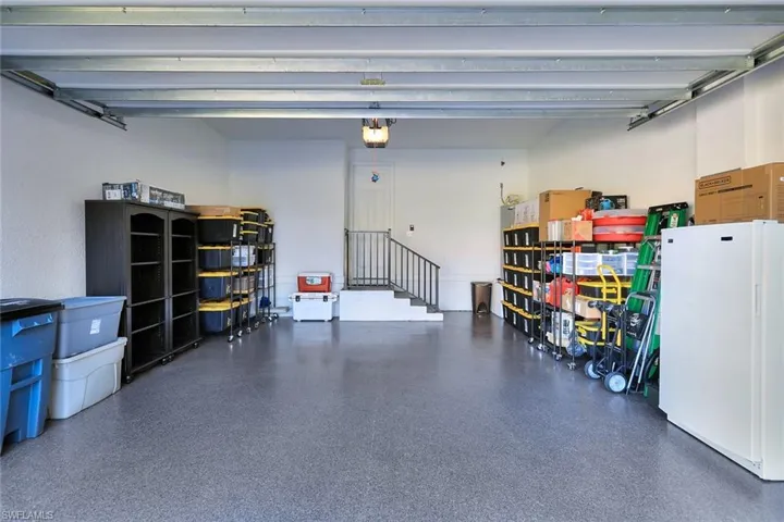 Garage featuring white refrigerator and a garage door opener