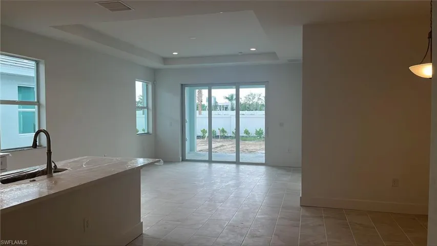 Great room with tray ceiling and casual dining area