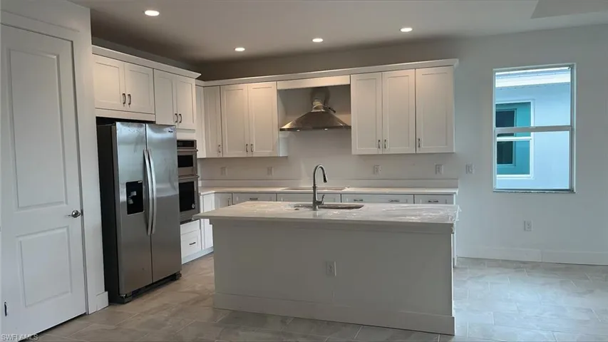 Kitchen layout with quartz countertops, soft-close cabinets and drawers, and stainless steel kitchen appliances