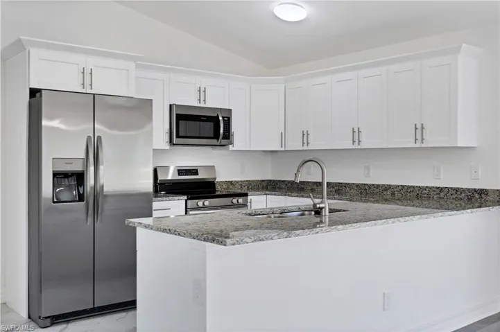 Kitchen with white cabinets, sink, stainless steel appliances