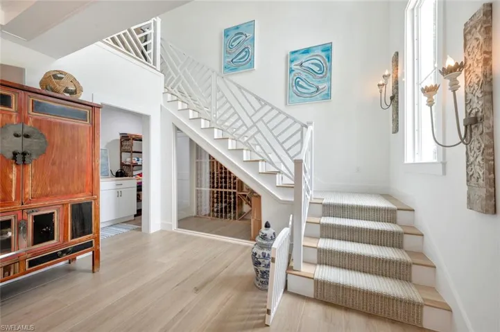 Staircase featuring wood finished floors and a high ceiling