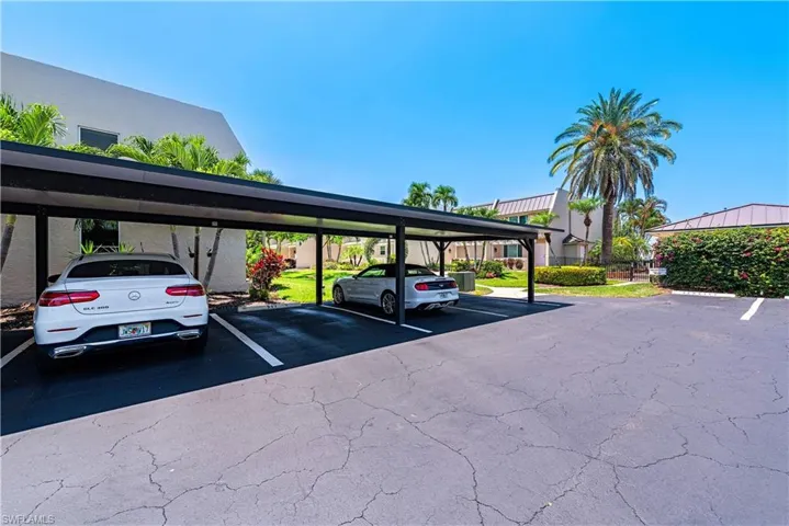 View of parking / parking lot featuring a carport