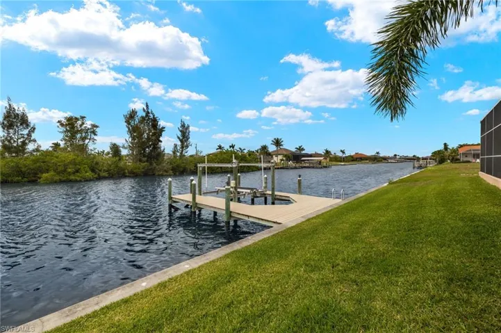 Dock featuring a lawn, a water view, and boat lift