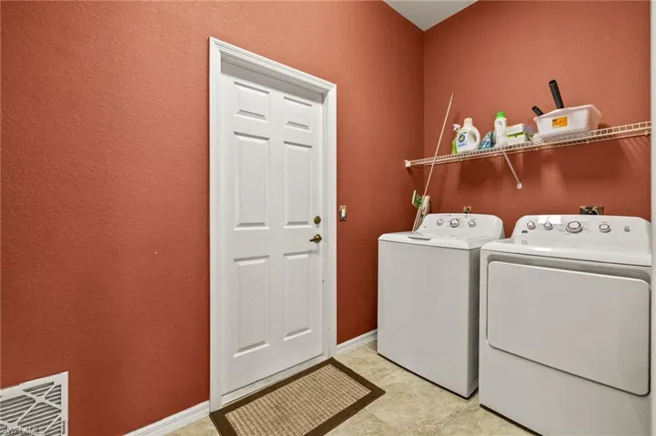 Laundry area featuring a textured wall and washer and dryer