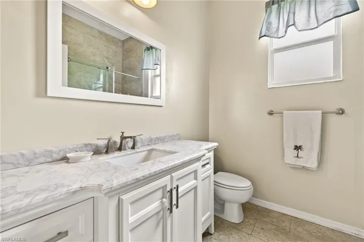 Full bathroom with vanity, light tile patterned floors, and a shower