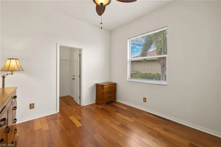 Unfurnished bedroom featuring ceiling fan, wood finished floors, and a spacious closet