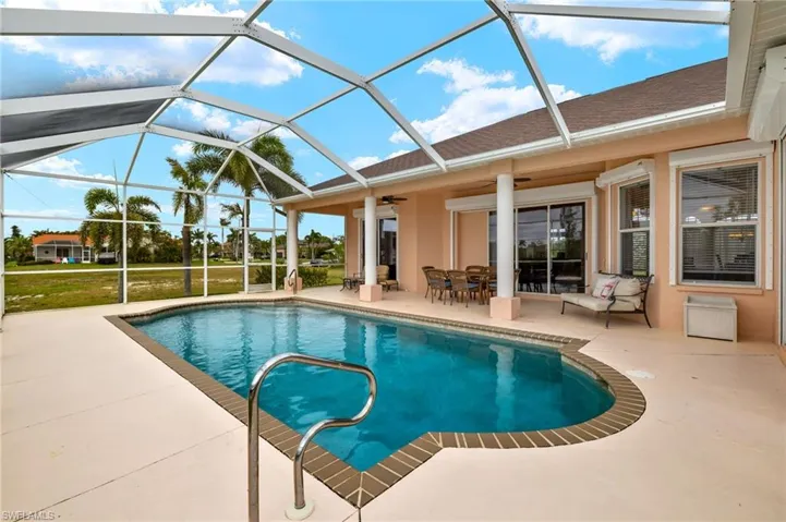 Outdoor pool with a sunroom, a patio area, a lanai, and a yard