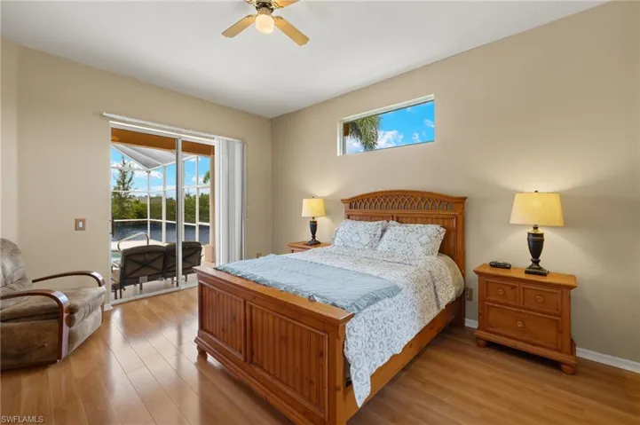Bedroom with access to outside, light wood finished floors, and a ceiling fan