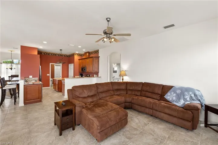 Living room featuring recessed lighting, arched walkways, and a ceiling fan