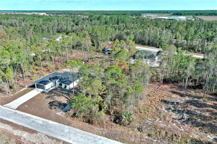 Aerial overview of property's location with a heavily wooded area
