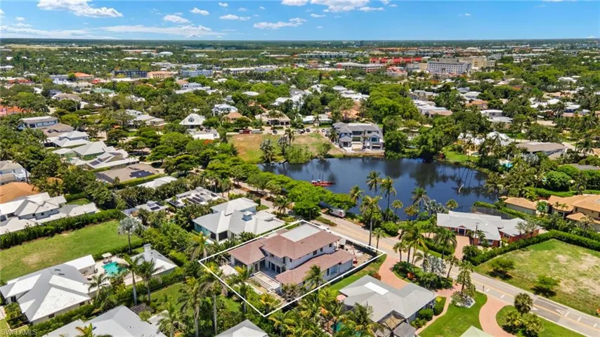 Aerial view of residential area with a large body of water and property boundaries highlighted